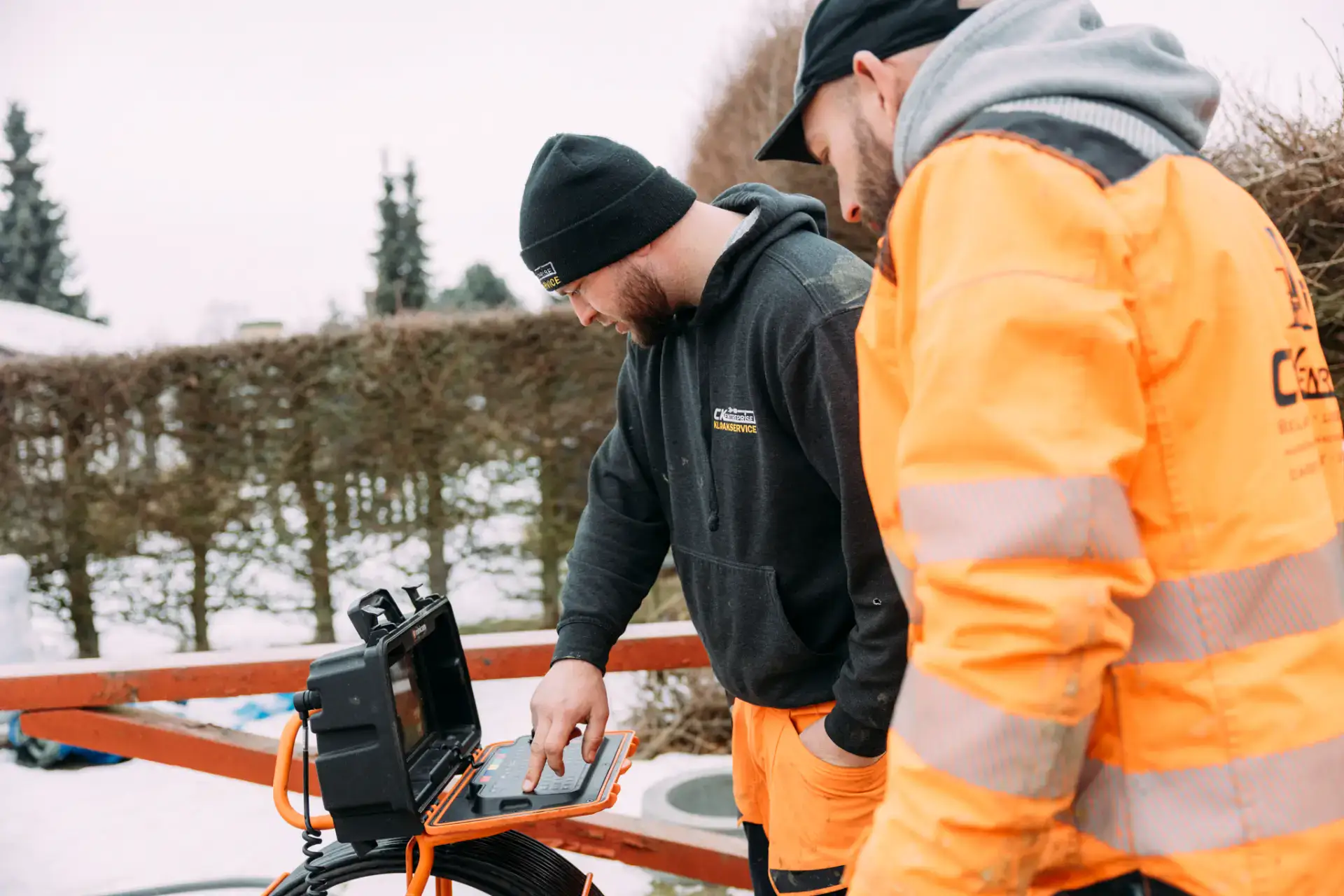 Kloakservice eksperter arbejder med avanceret udstyr i vintervejr.