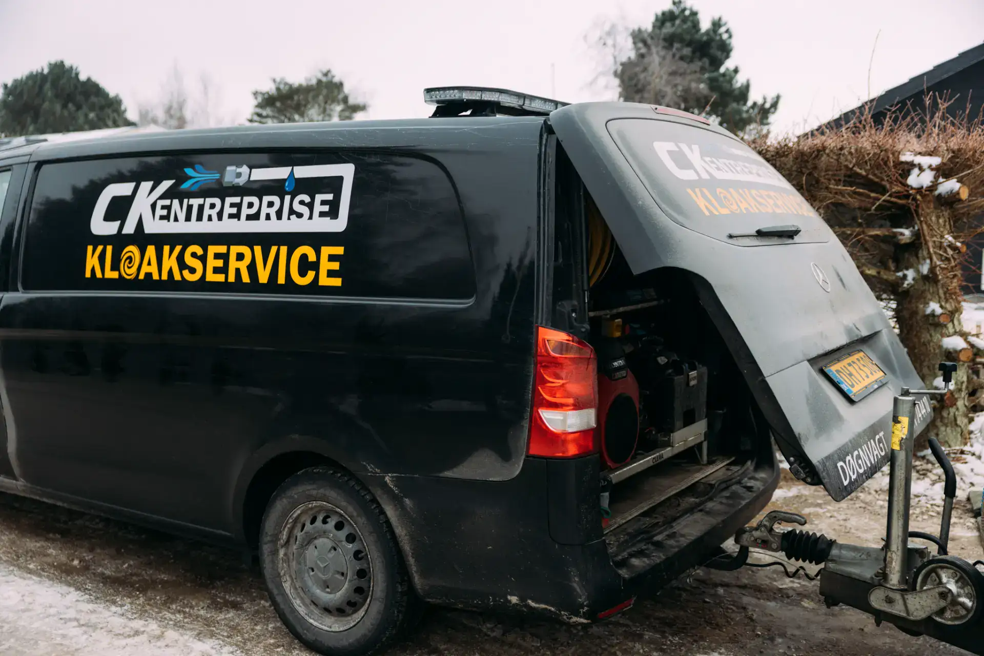 Kloakservice varebil med udstyr til kloakreparationer.