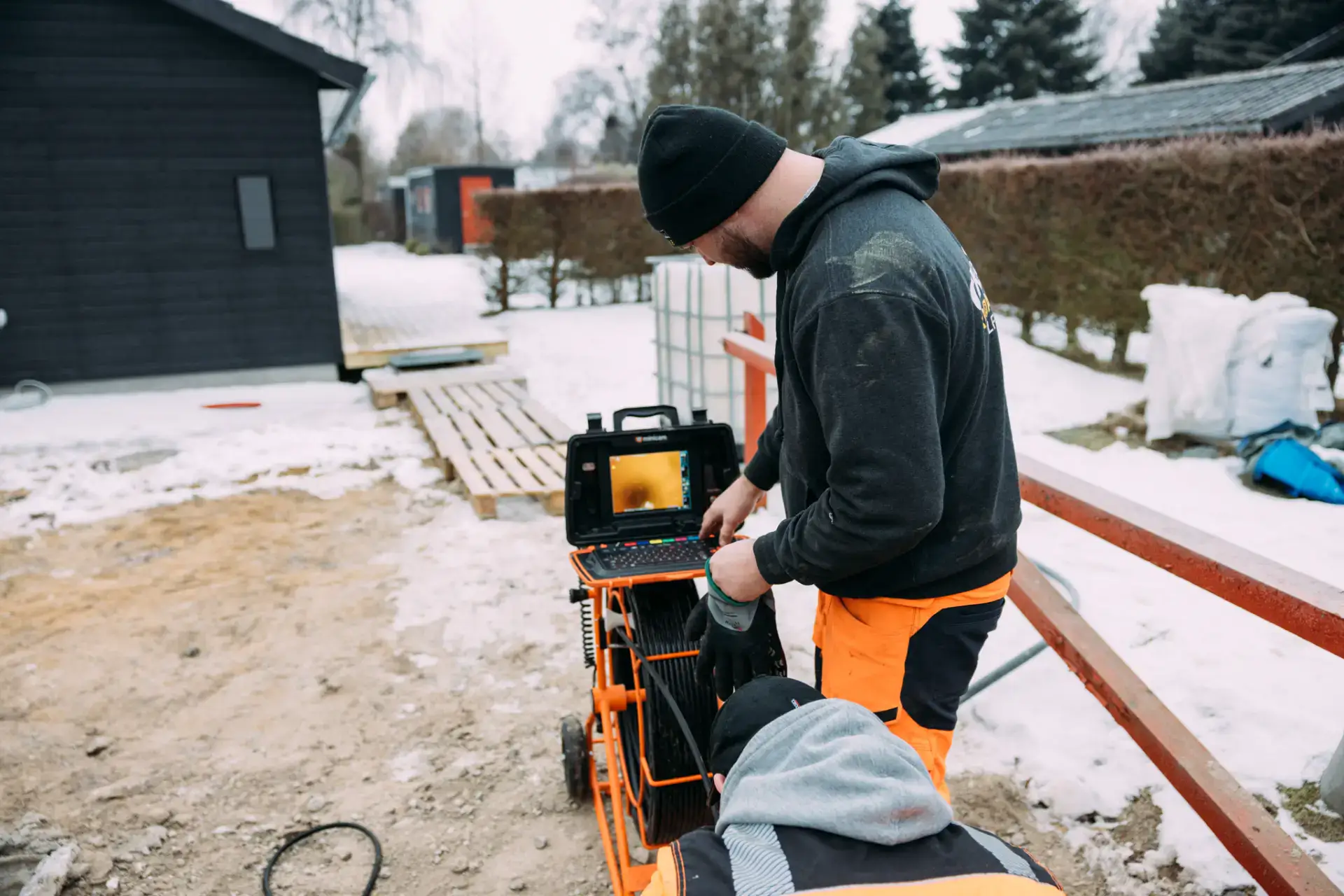 VVS-arbejder udendørs med specialudstyr i vintervejr.